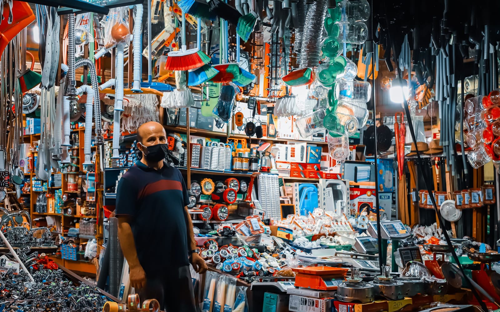 A hardware shop packed floor to ceiling with stock, one person behind the counter