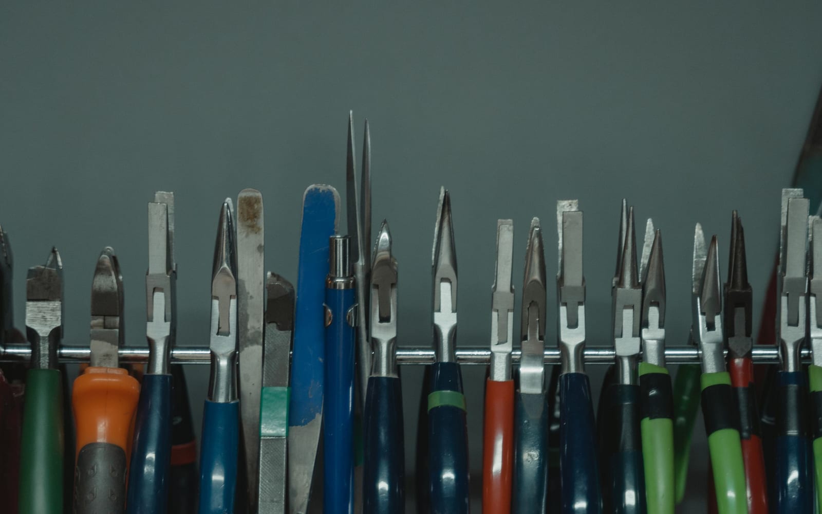 A rack of hand tools with worn handles, some used far more than others