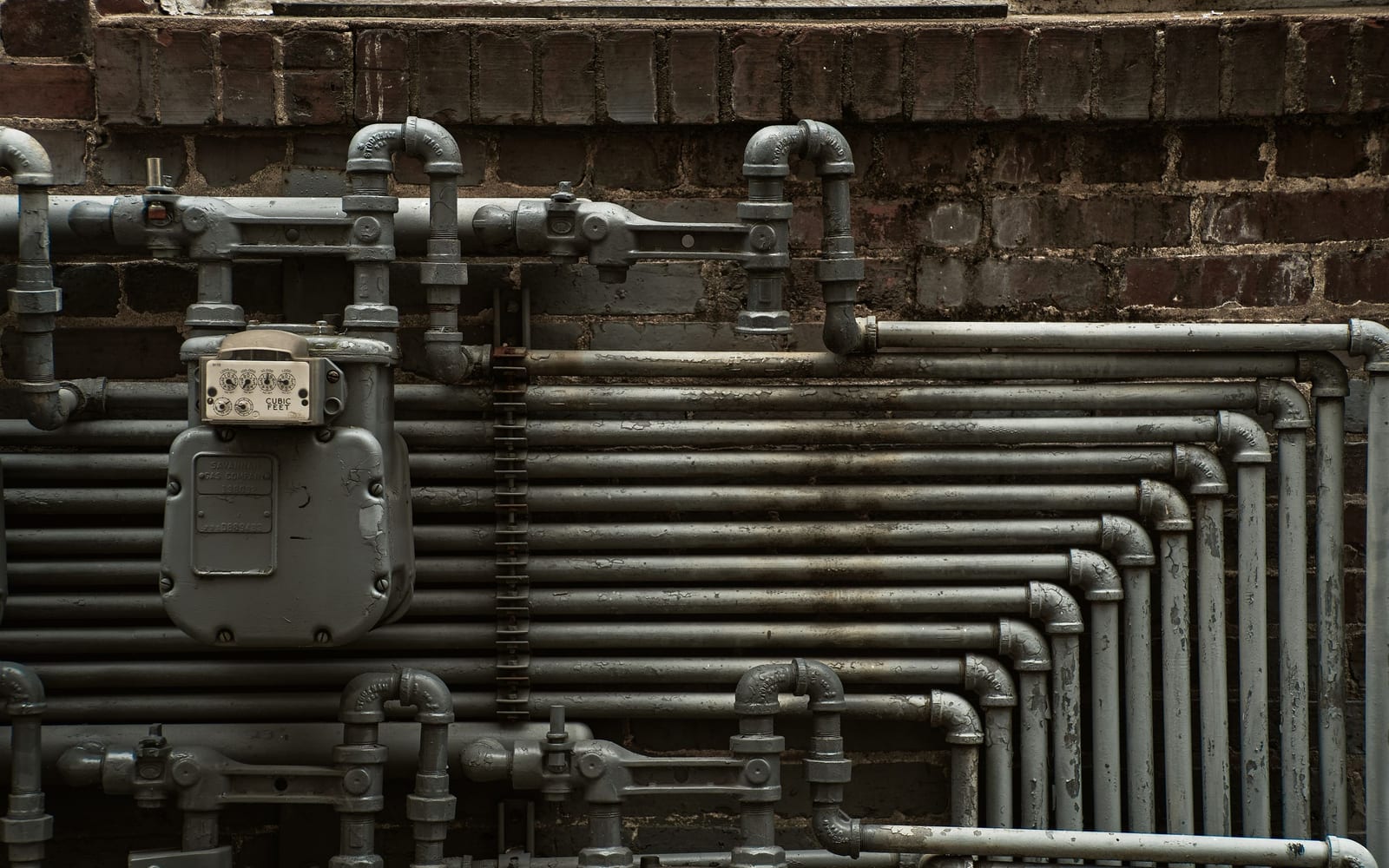 A dense grid of industrial pipework routed through a metered manifold