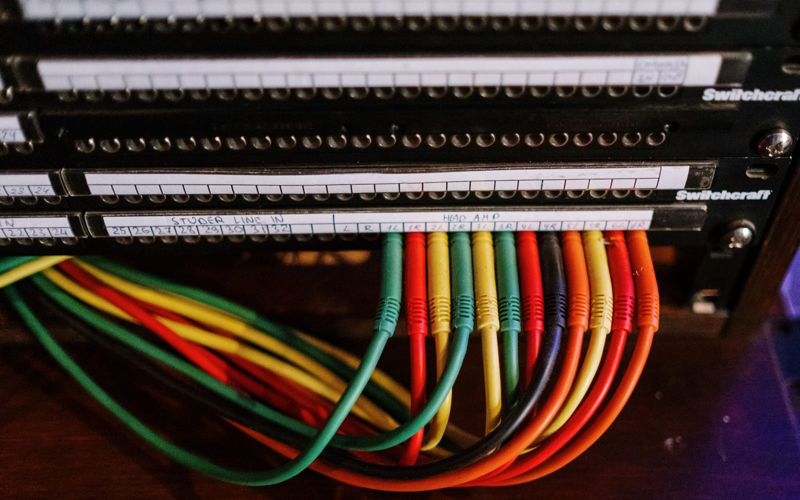 A network patch panel with colour-coded cables neatly terminated and labelled
