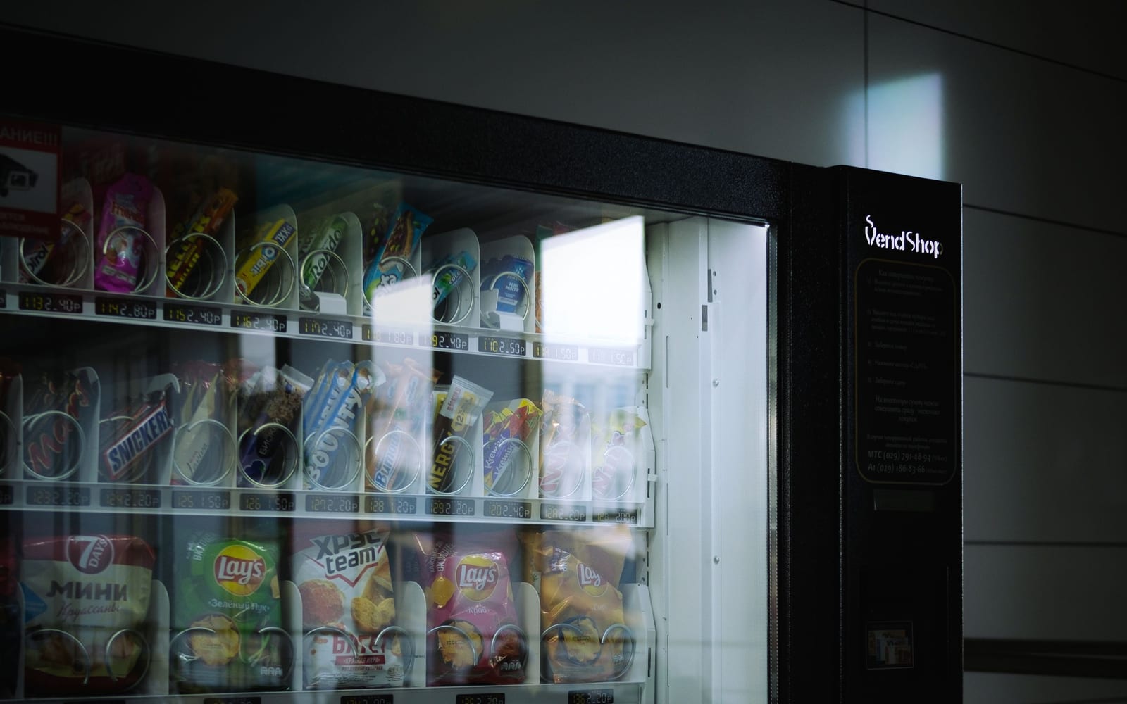 A vending machine seen through its glass front, products in numbered slots