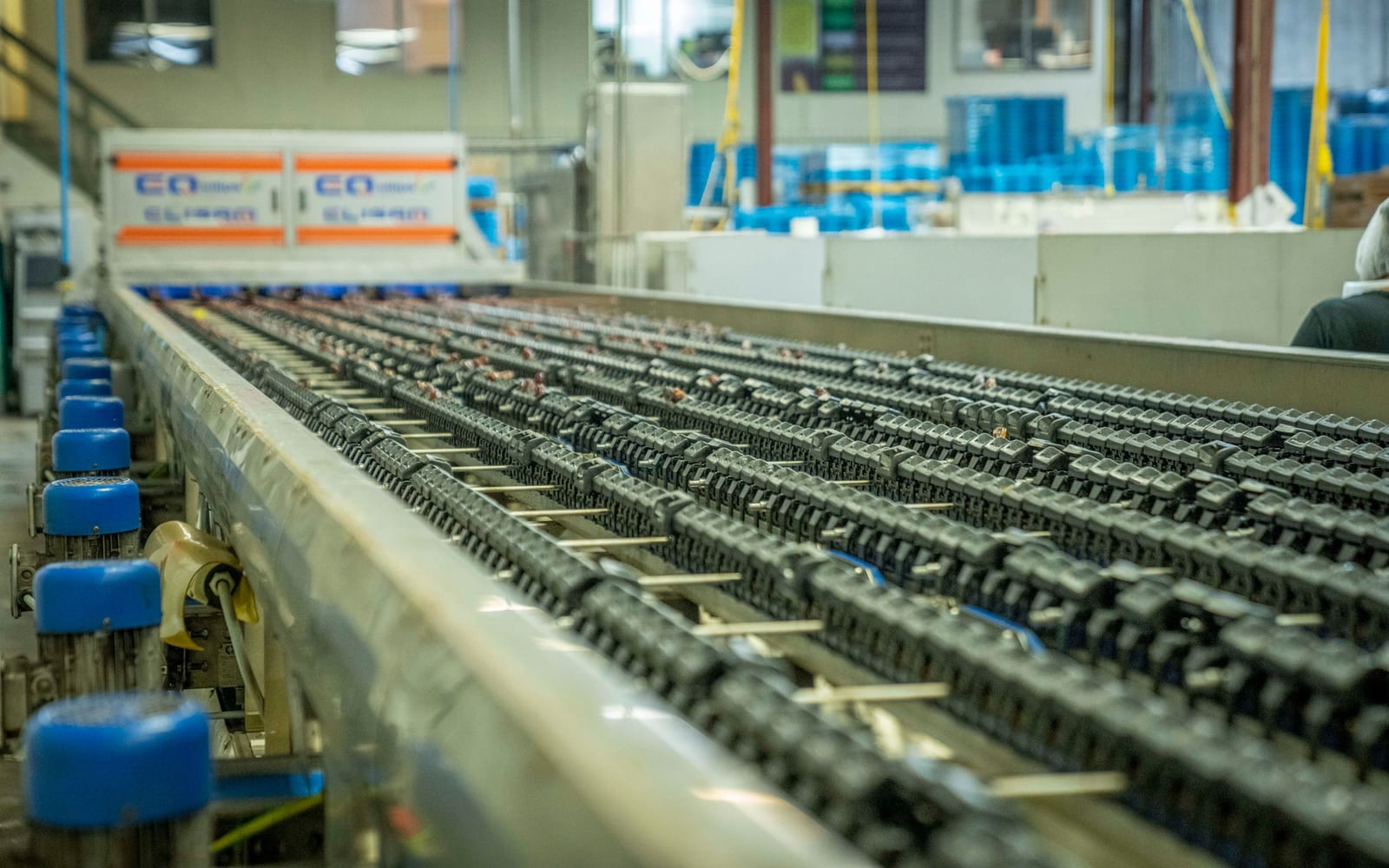 A long factory production line with sequential work stations receding into the distance
