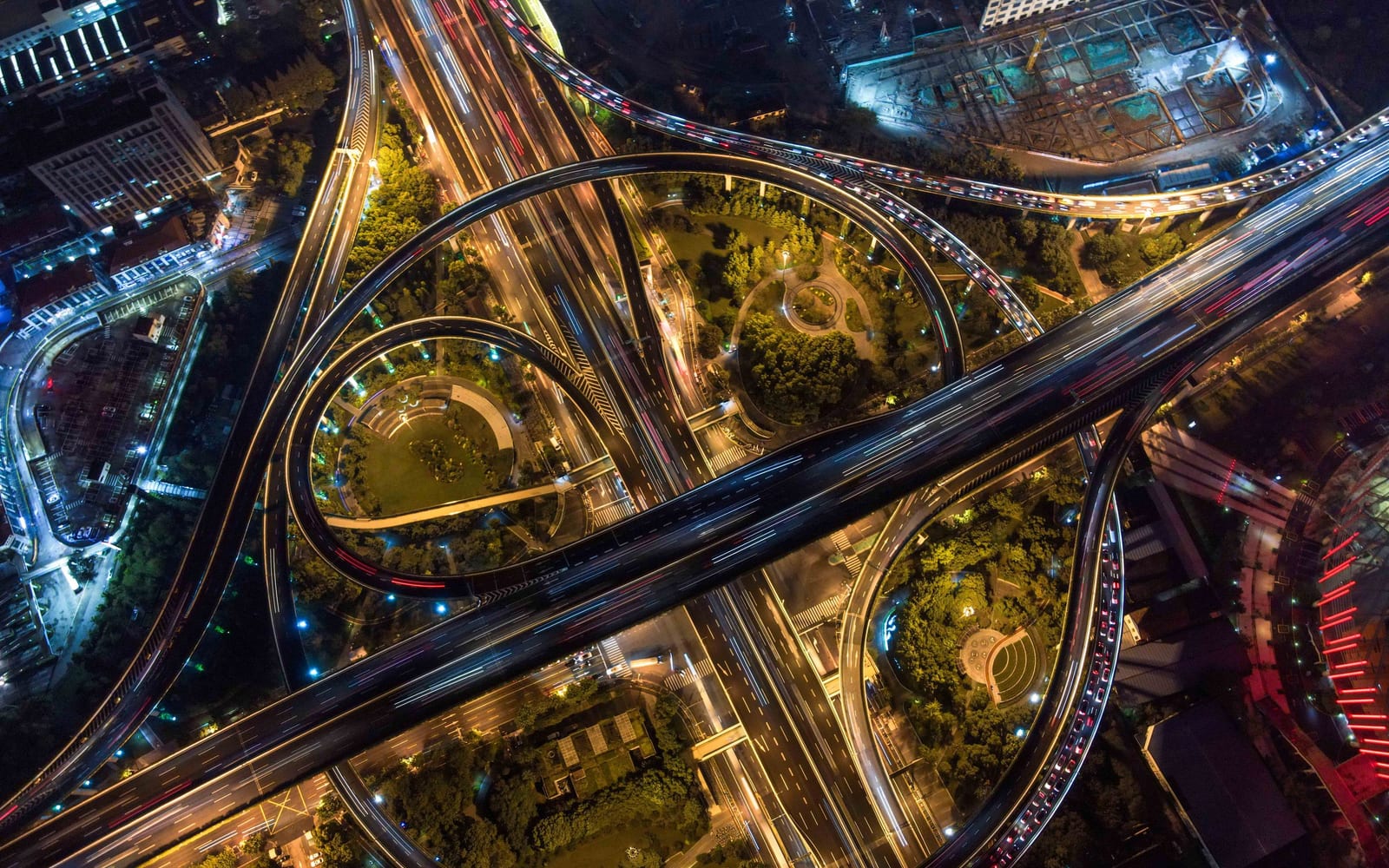 A multi level road interchange lit at night, each carriageway crossing the others without merging