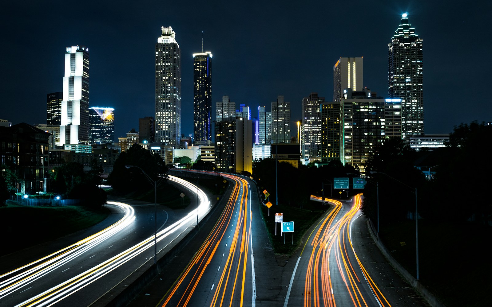 Long-exposure traffic trails through a city at night