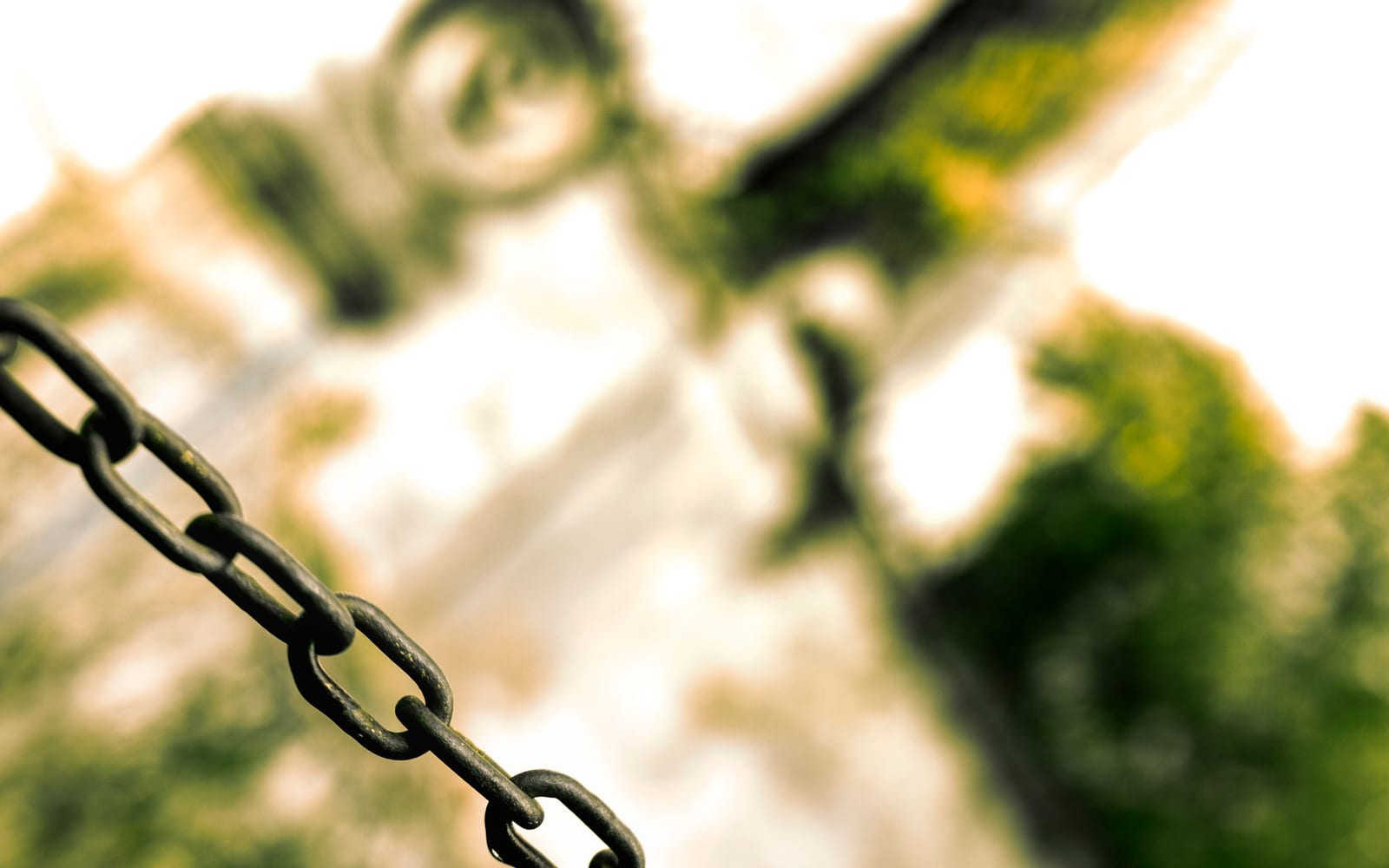 A taut metal chain with its links visible, receding out of focus