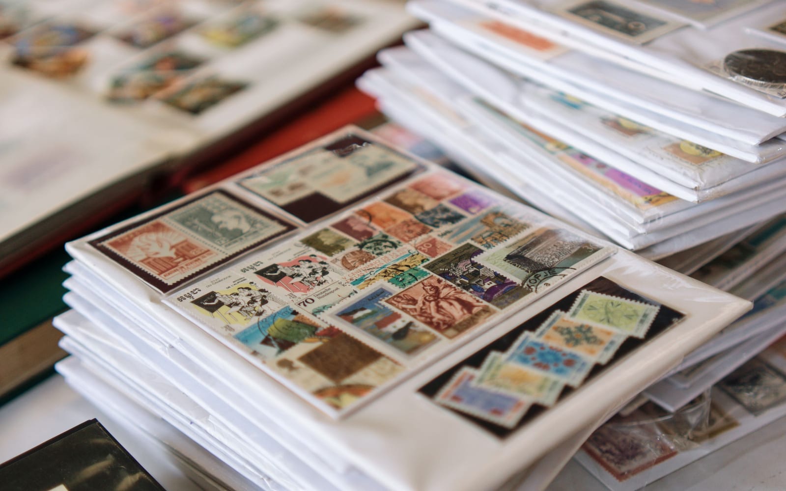 Collected postage stamps sorted and mounted across album sheets