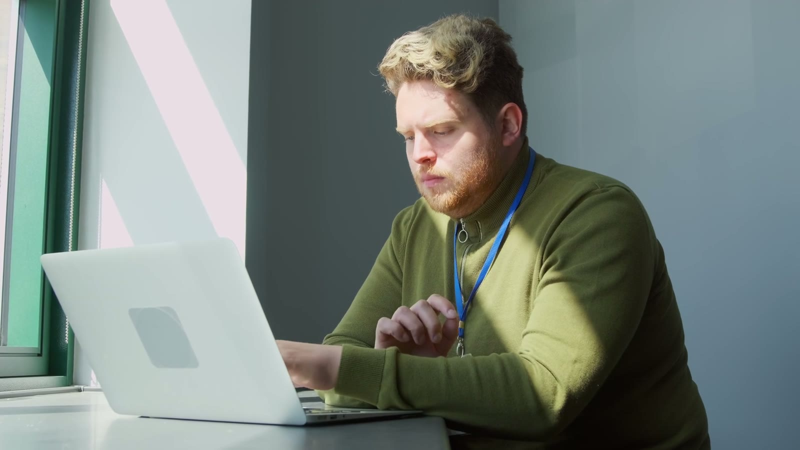 A reviewer working through an approval on a laptop by a window.