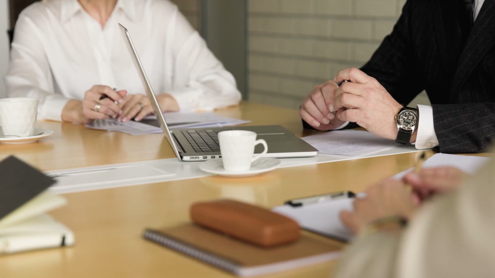 A steering group reviewing papers and a laptop around a meeting table.