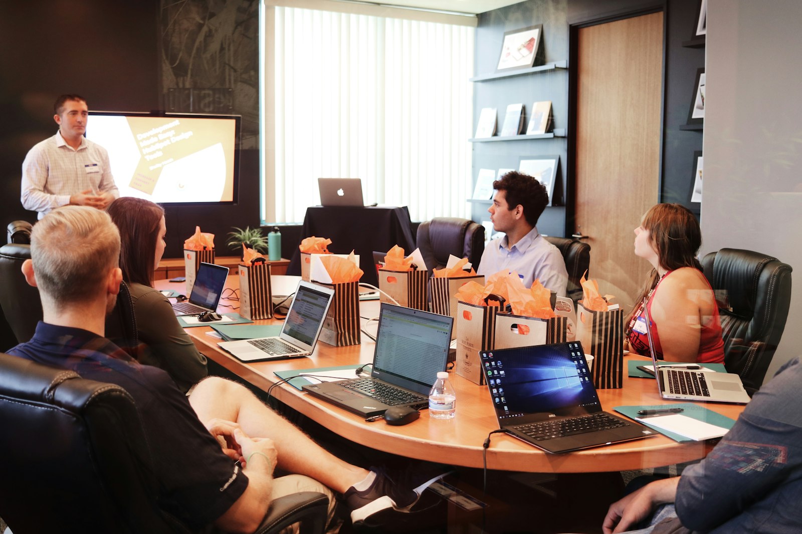 Professional services workshop with presenter and laptops around the table, the delivery surface that must stay honest with pursuits and renewals.