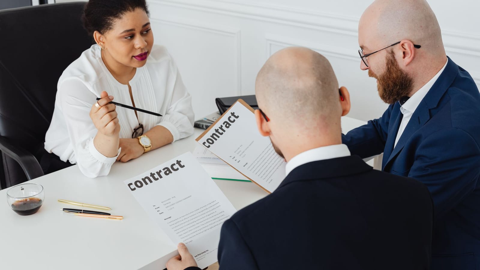 Two people reviewing contract terms across a desk.