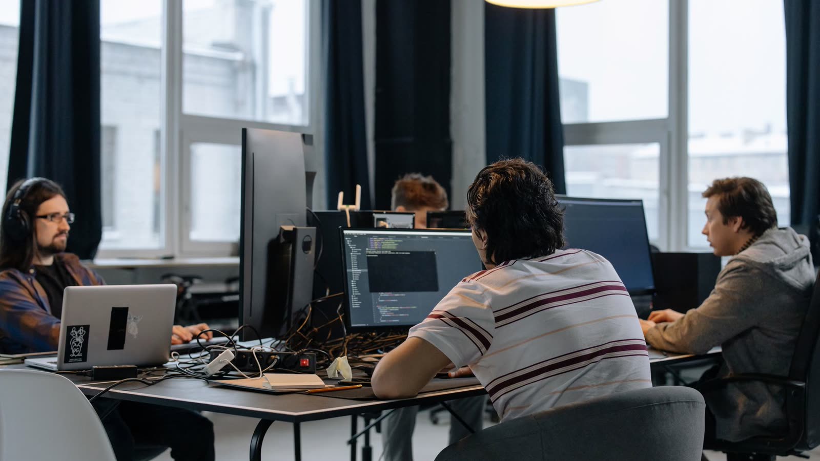 An open-plan engineering team working across desks and monitors.