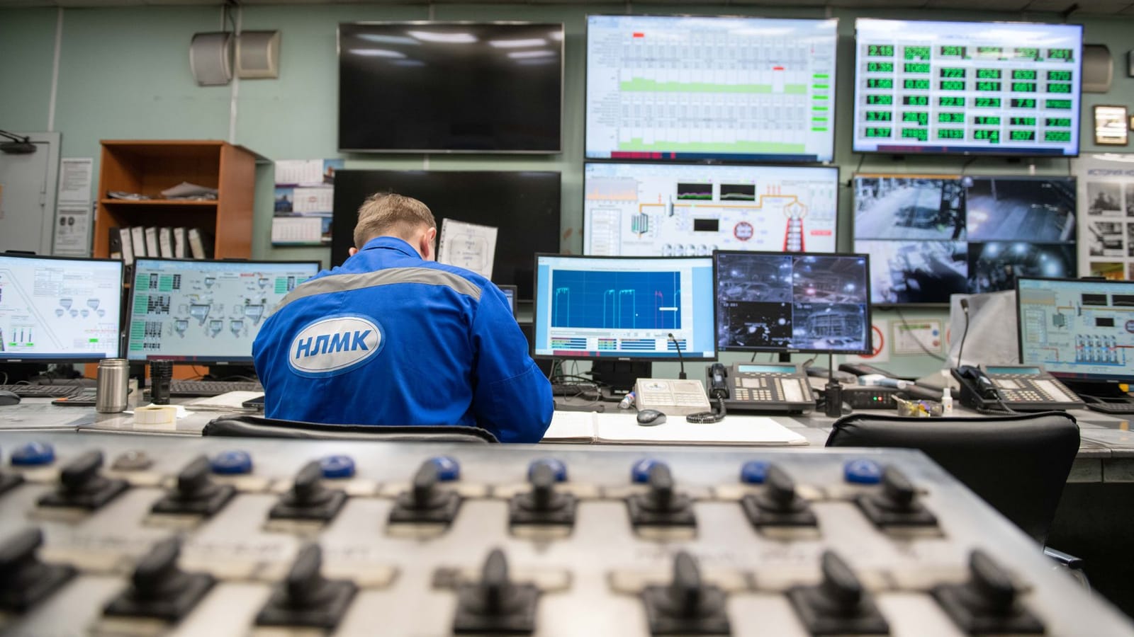 A dispatcher monitoring schedules across multiple screens in a control room.