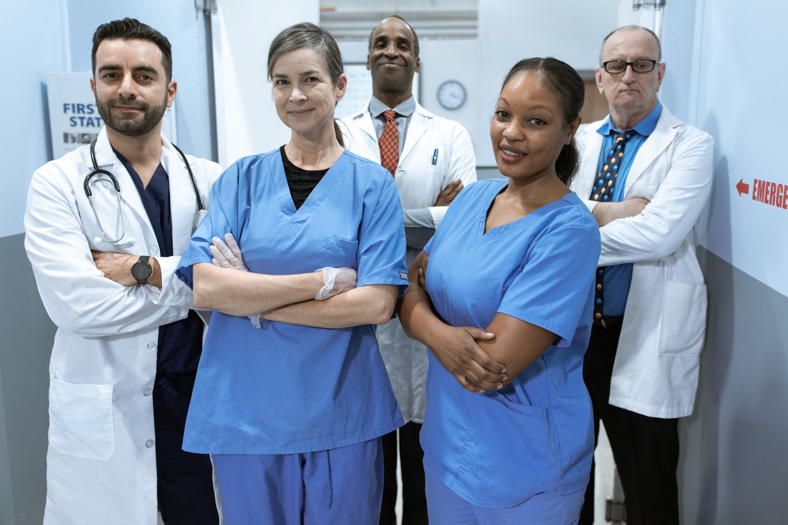 Multidisciplinary care team in a clinic corridor aligning before Health Cloud configuration scales.