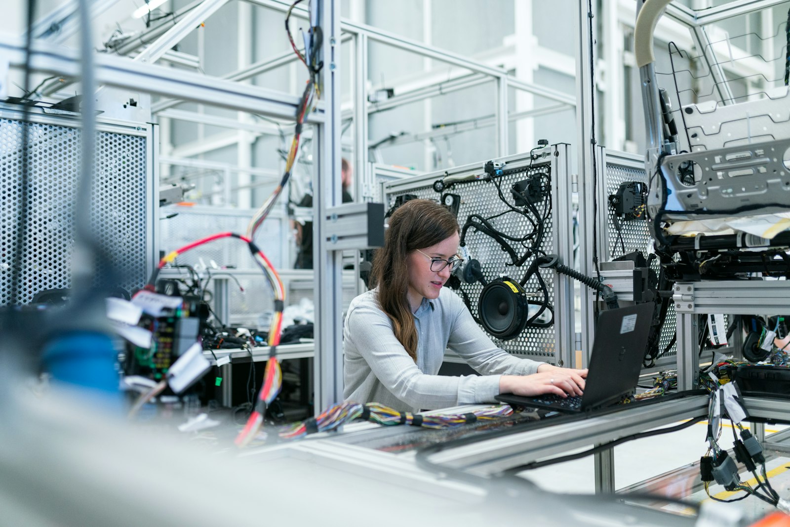 Automotive electronics engineer validating wiring harness and door-module test fixtures on a plant workstation.