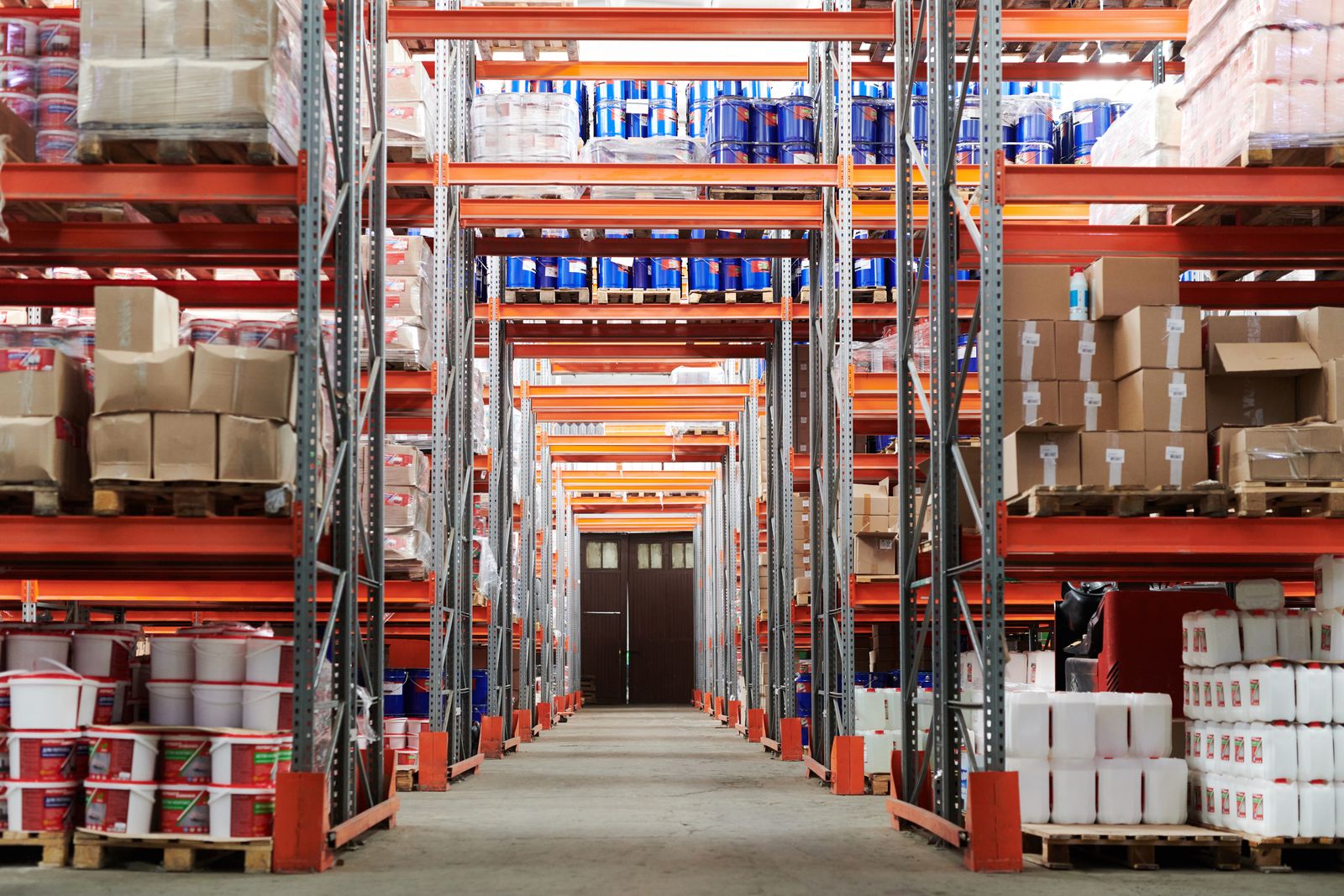 High-bay parts warehouse aisle, the inventory and claim truth Salesforce must not pretend to replace.