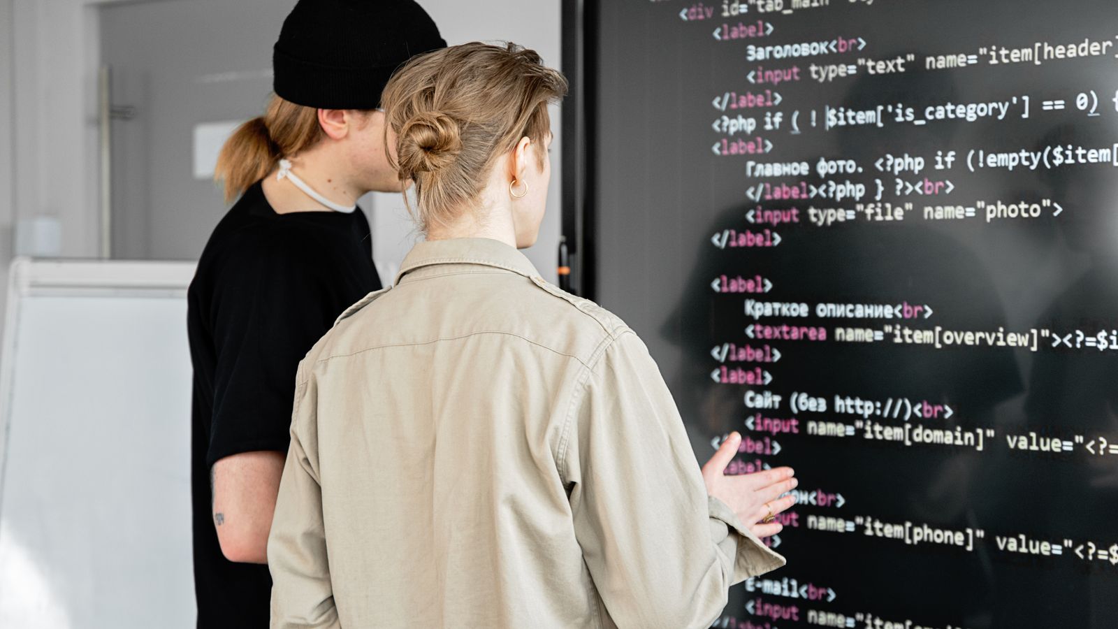 Two engineers reviewing code together at a workstation.