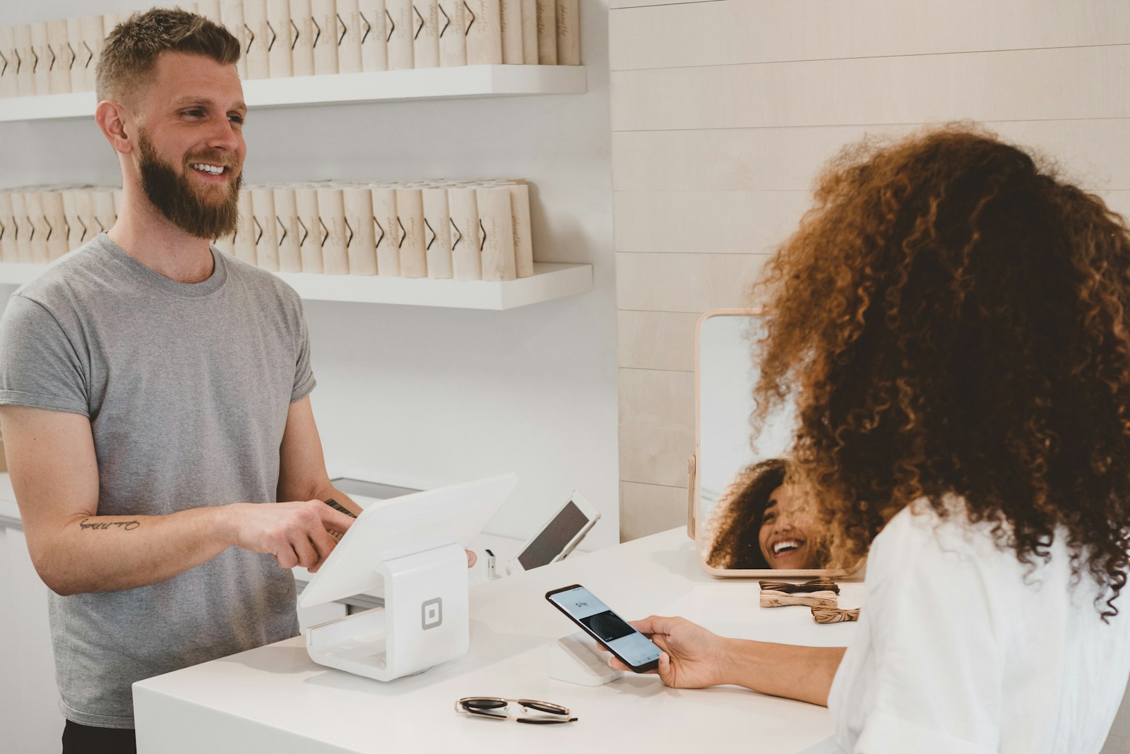 Retail associate and shopper completing a contactless purchase at a modern boutique POS.
