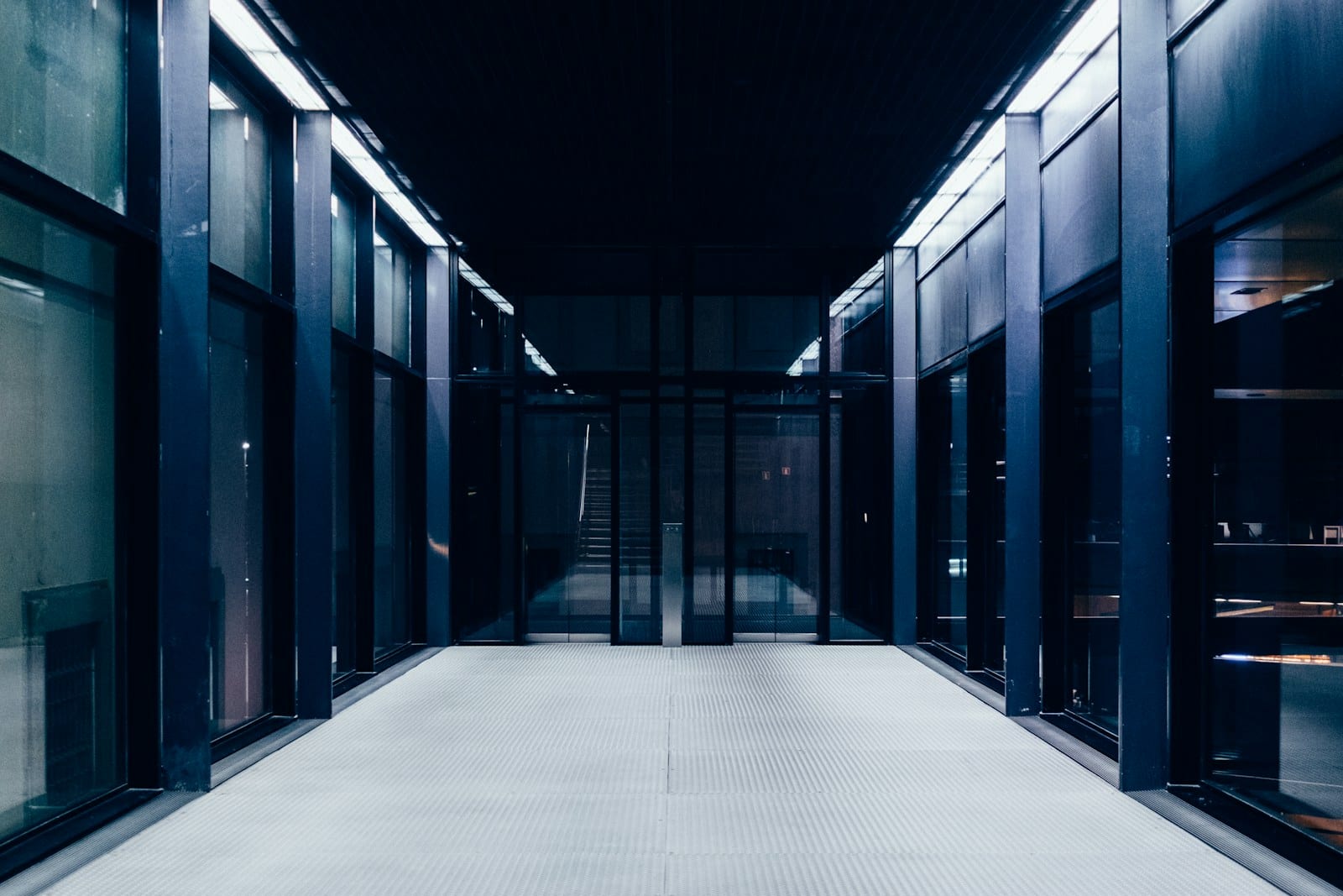 A controlled-access corridor with glass doors leading to a secured area.