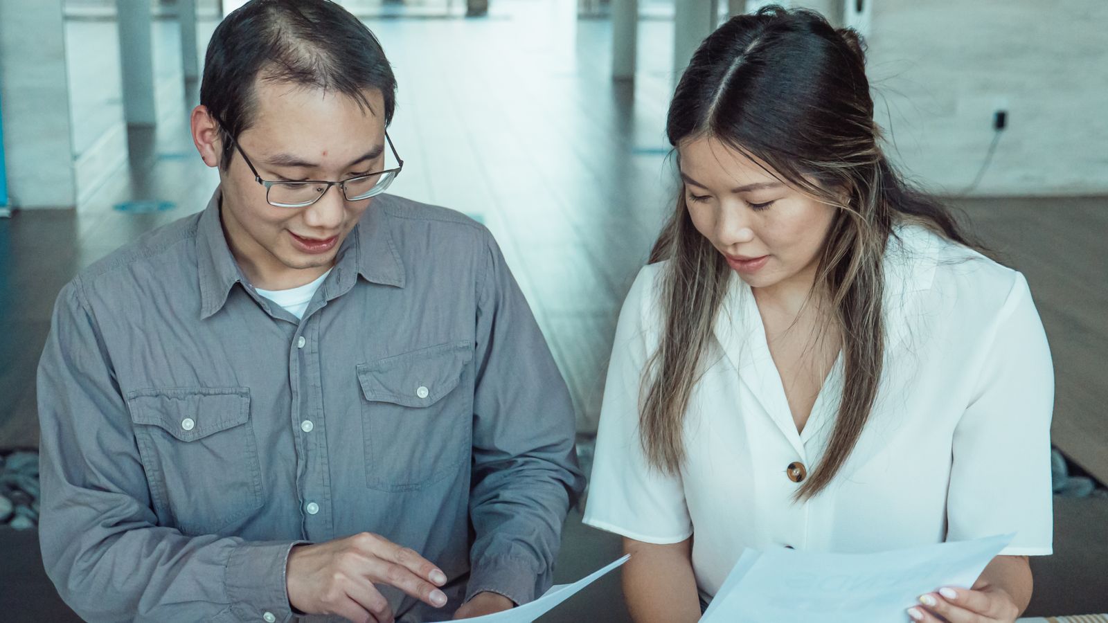 Two colleagues reviewing a proposal document together.