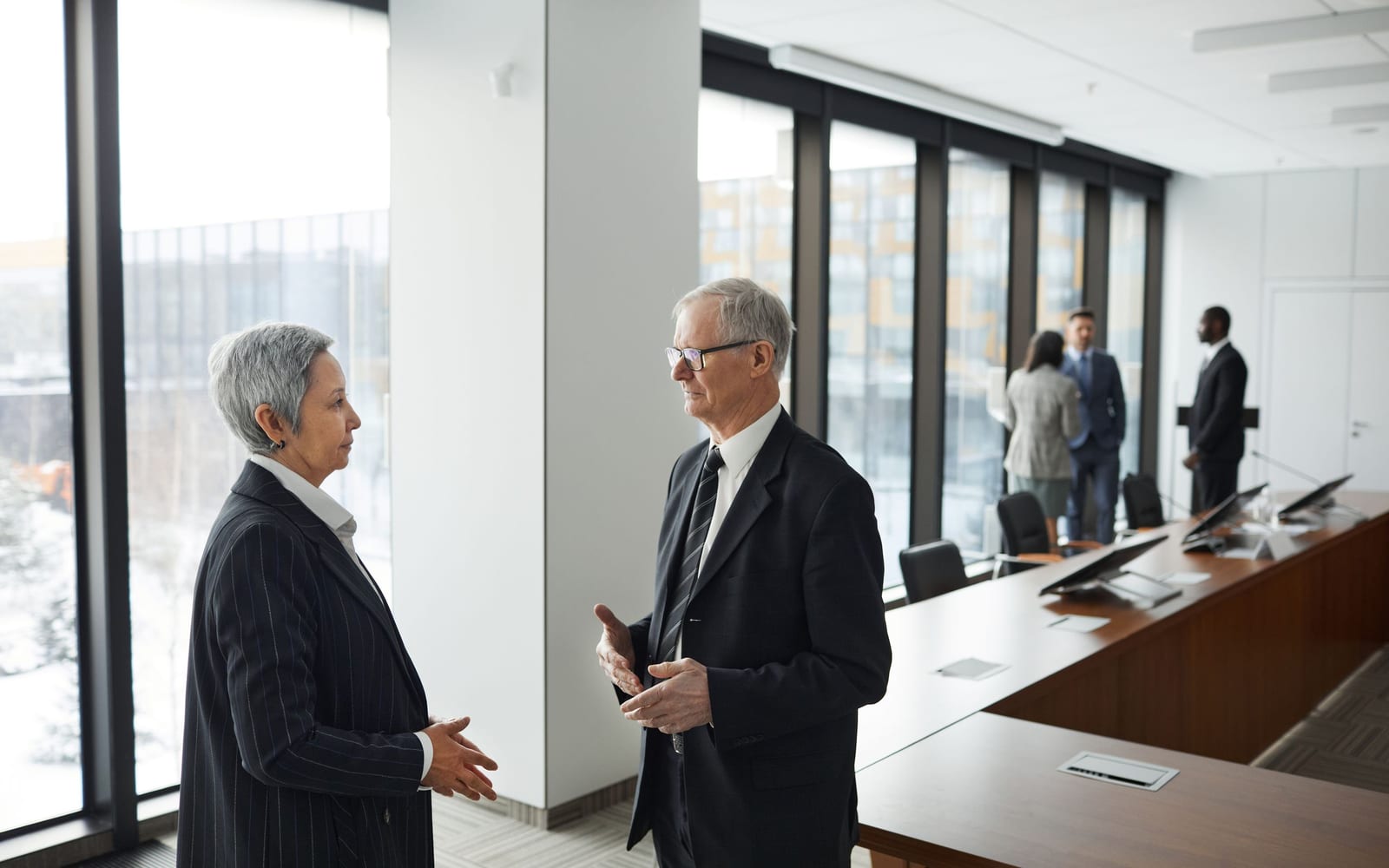 An enterprise meeting in a glass-walled conference room.