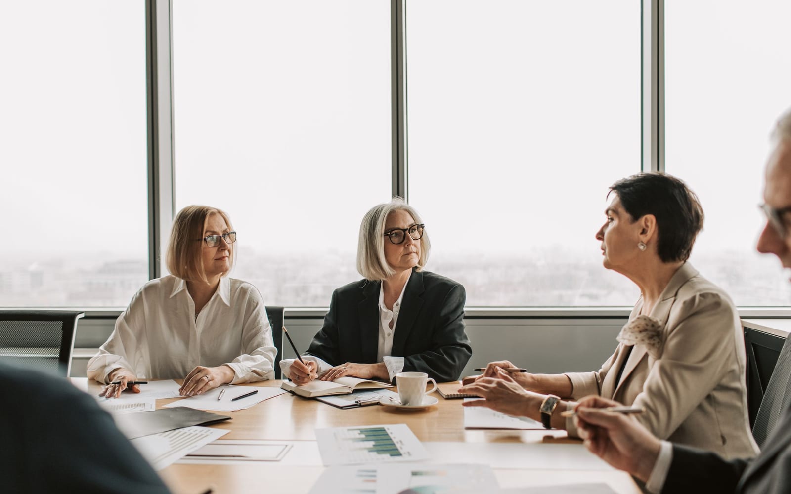 An enterprise meeting in a glass-walled conference room.