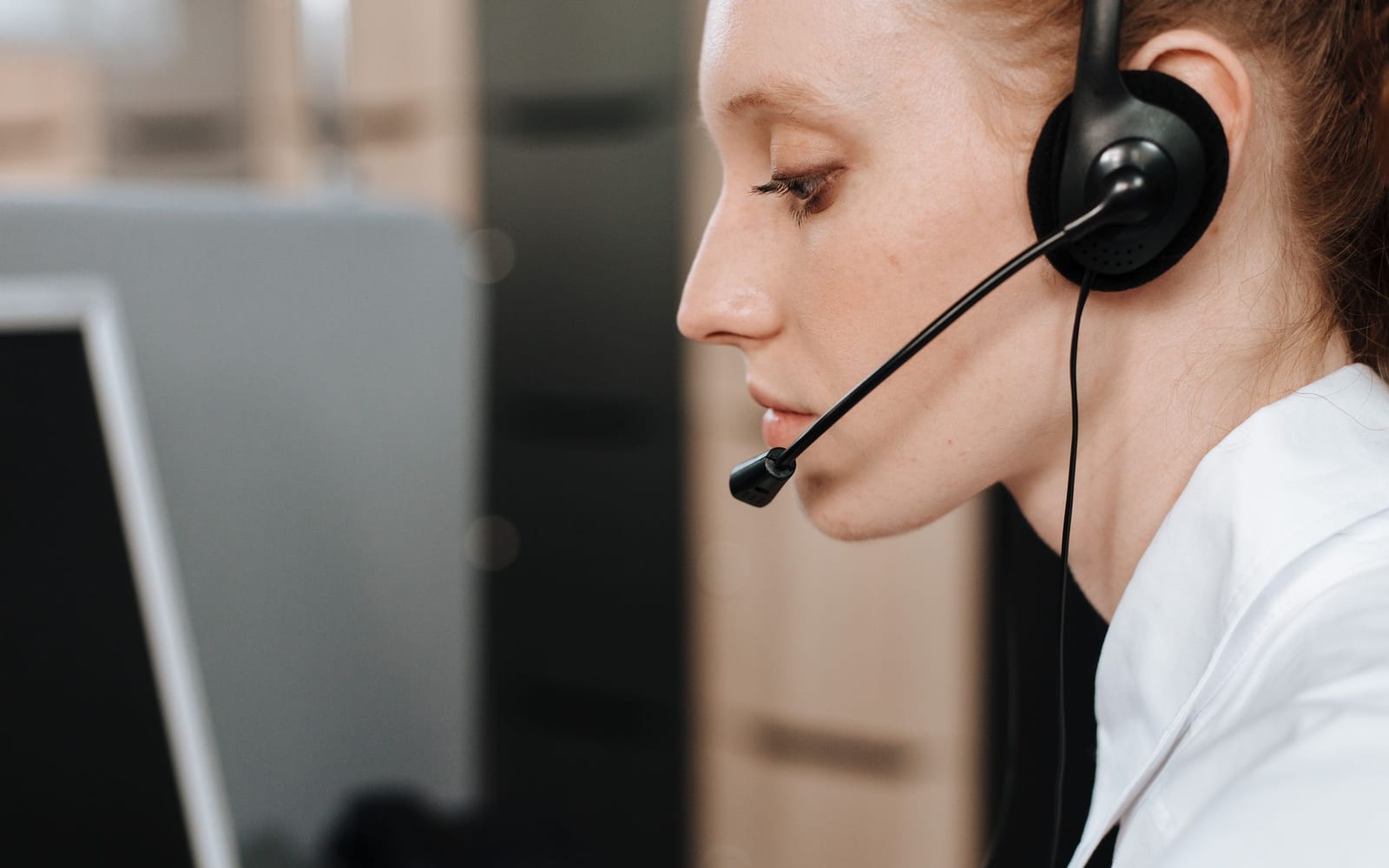 A service agent working with a headset in a contact centre.