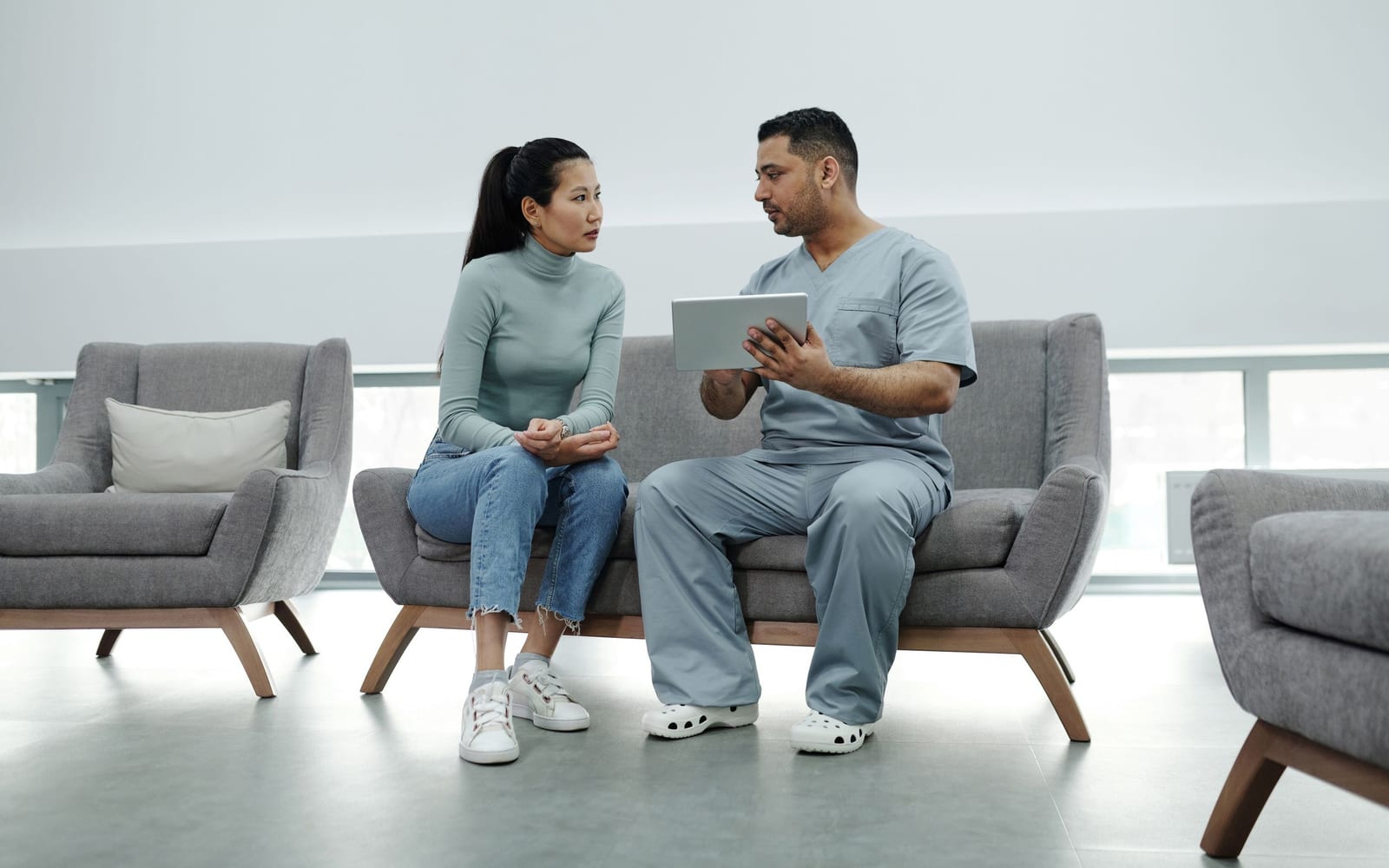 A clinician using a tablet in a hospital.