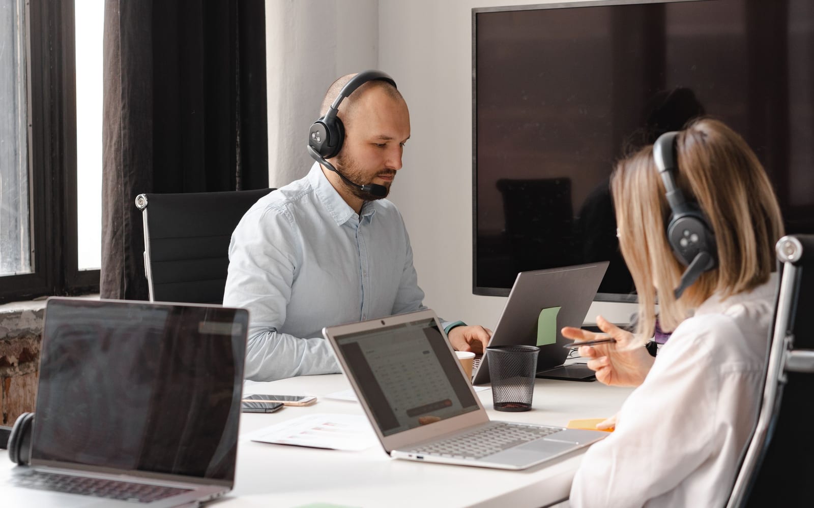 A service agent working with a headset in a contact centre.