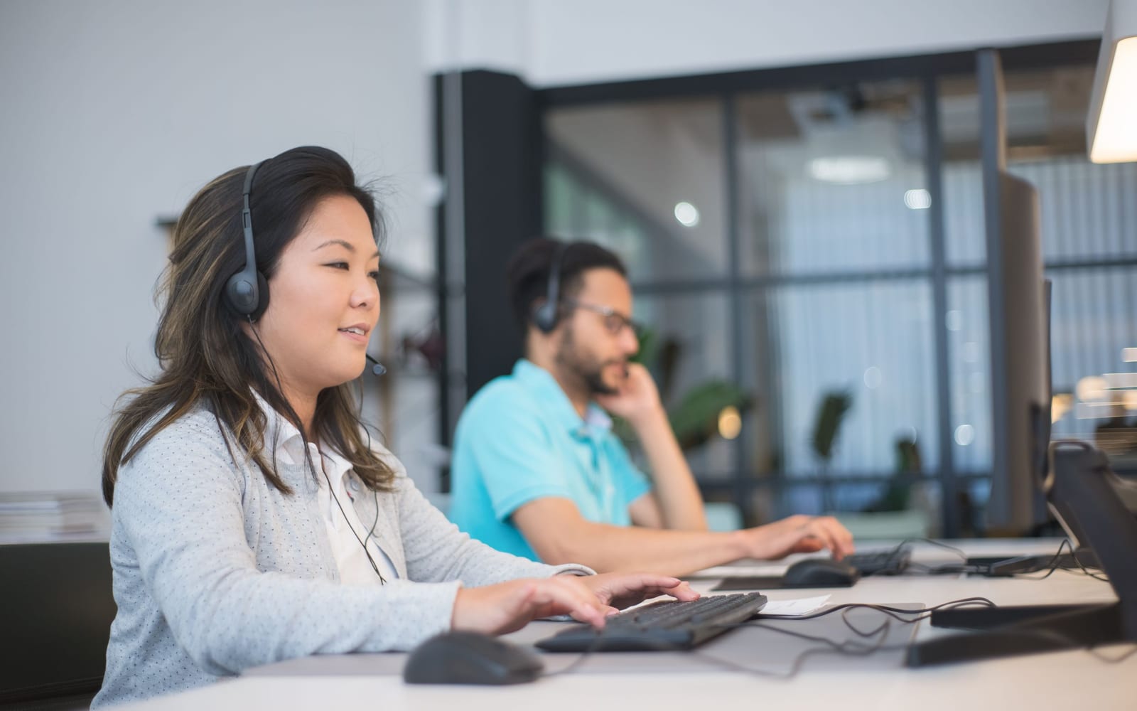A service agent working with a headset in a contact centre.