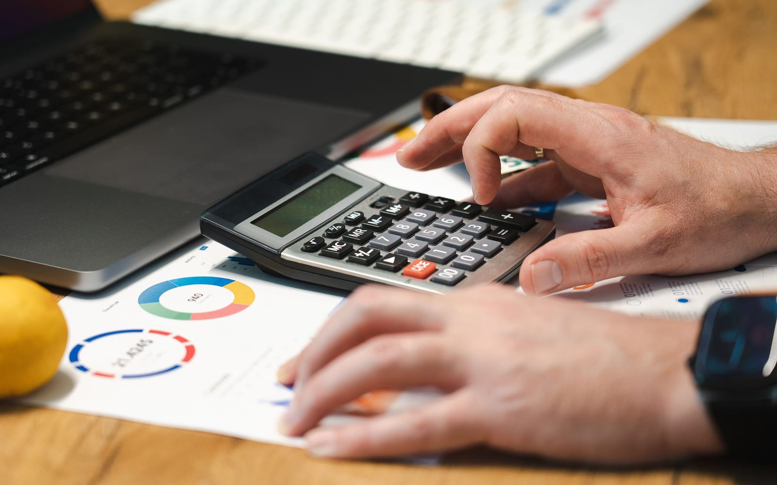 An analyst reviewing figures on a laptop in an office.