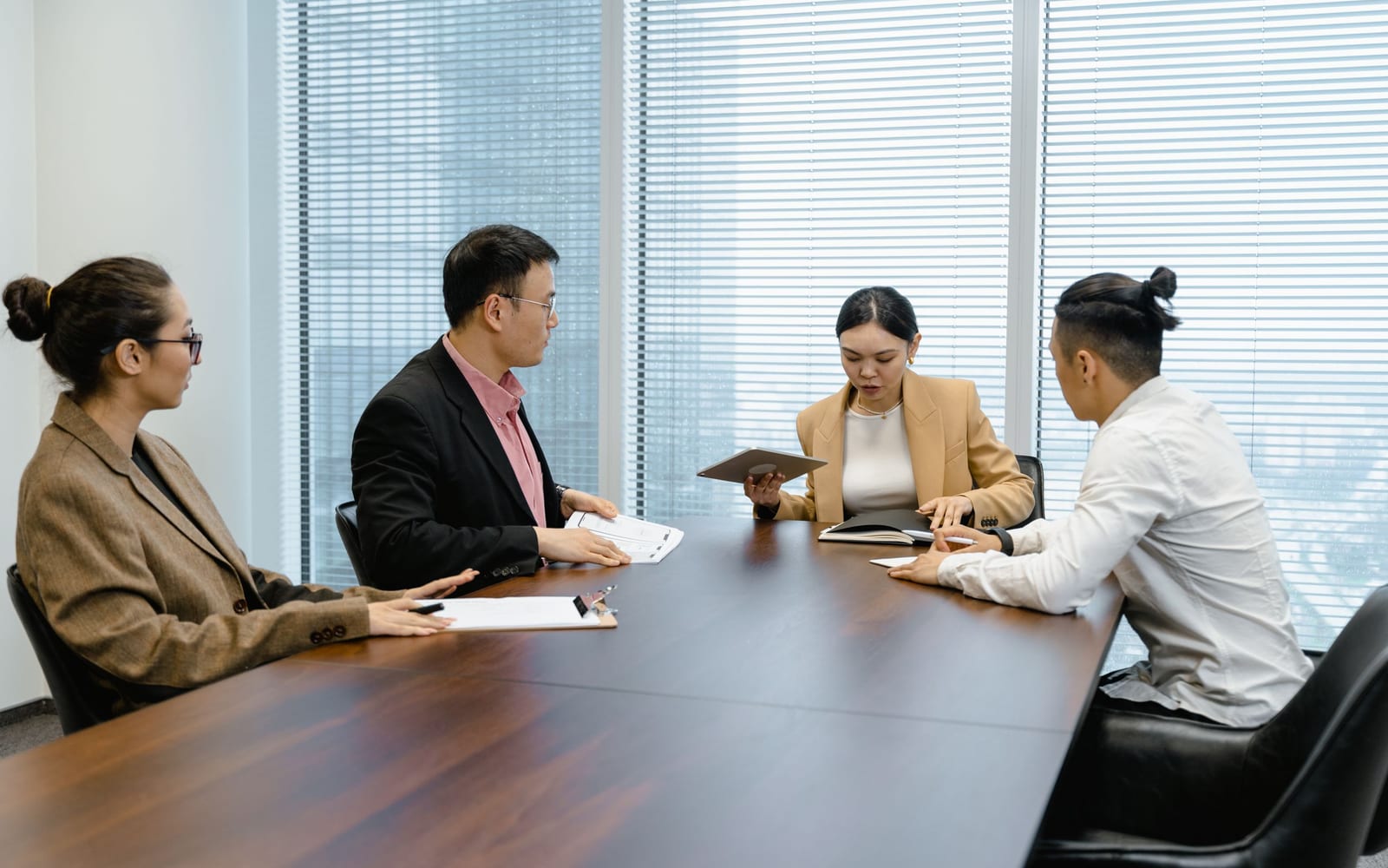 An enterprise meeting in a glass-walled conference room.