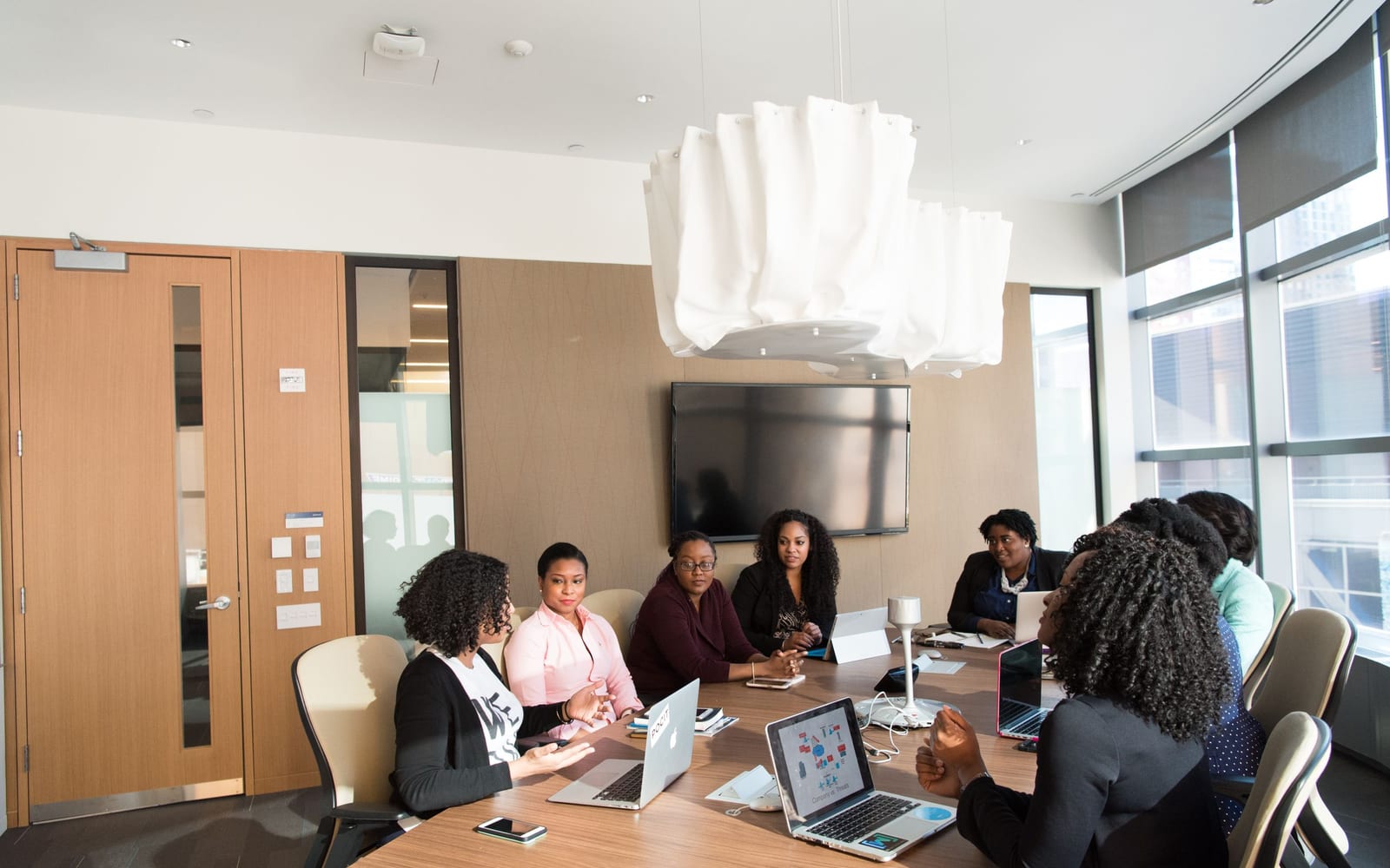 An enterprise meeting in a glass-walled conference room.