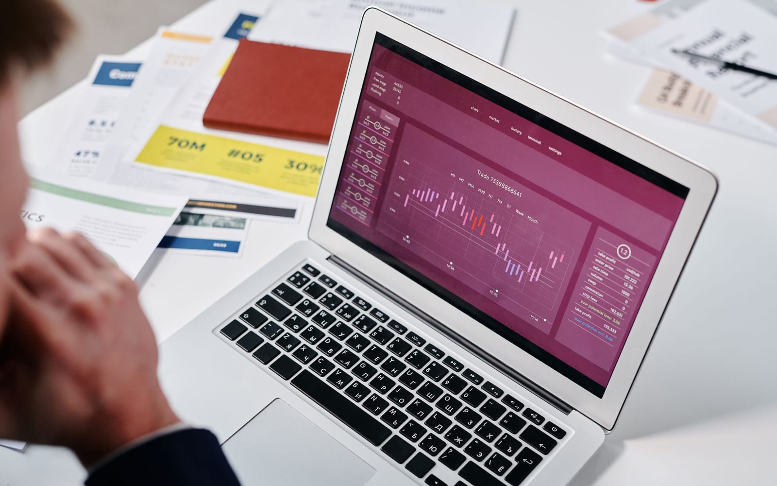 An analyst reviewing figures on a laptop in an office.