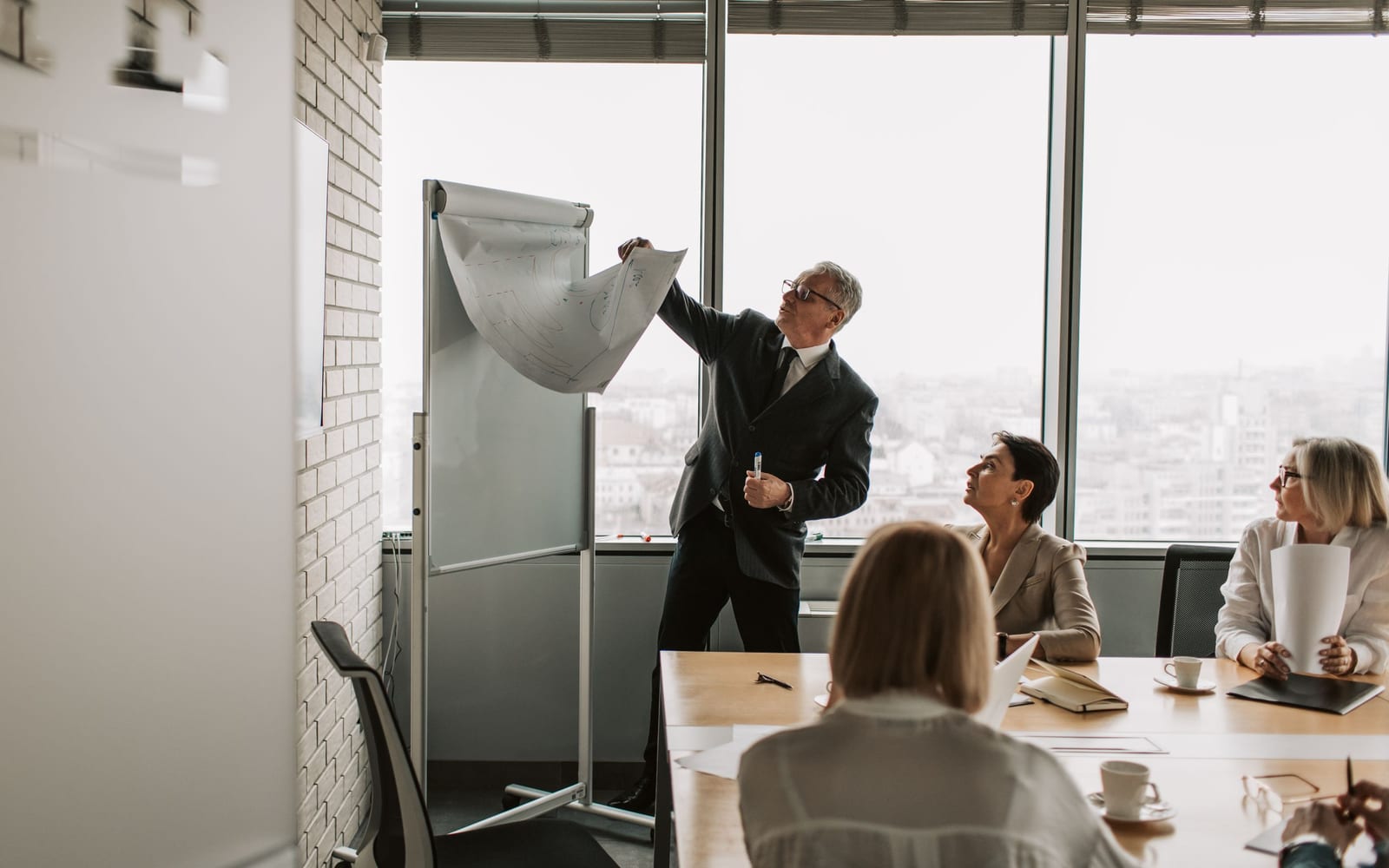 An enterprise meeting in a glass-walled conference room.