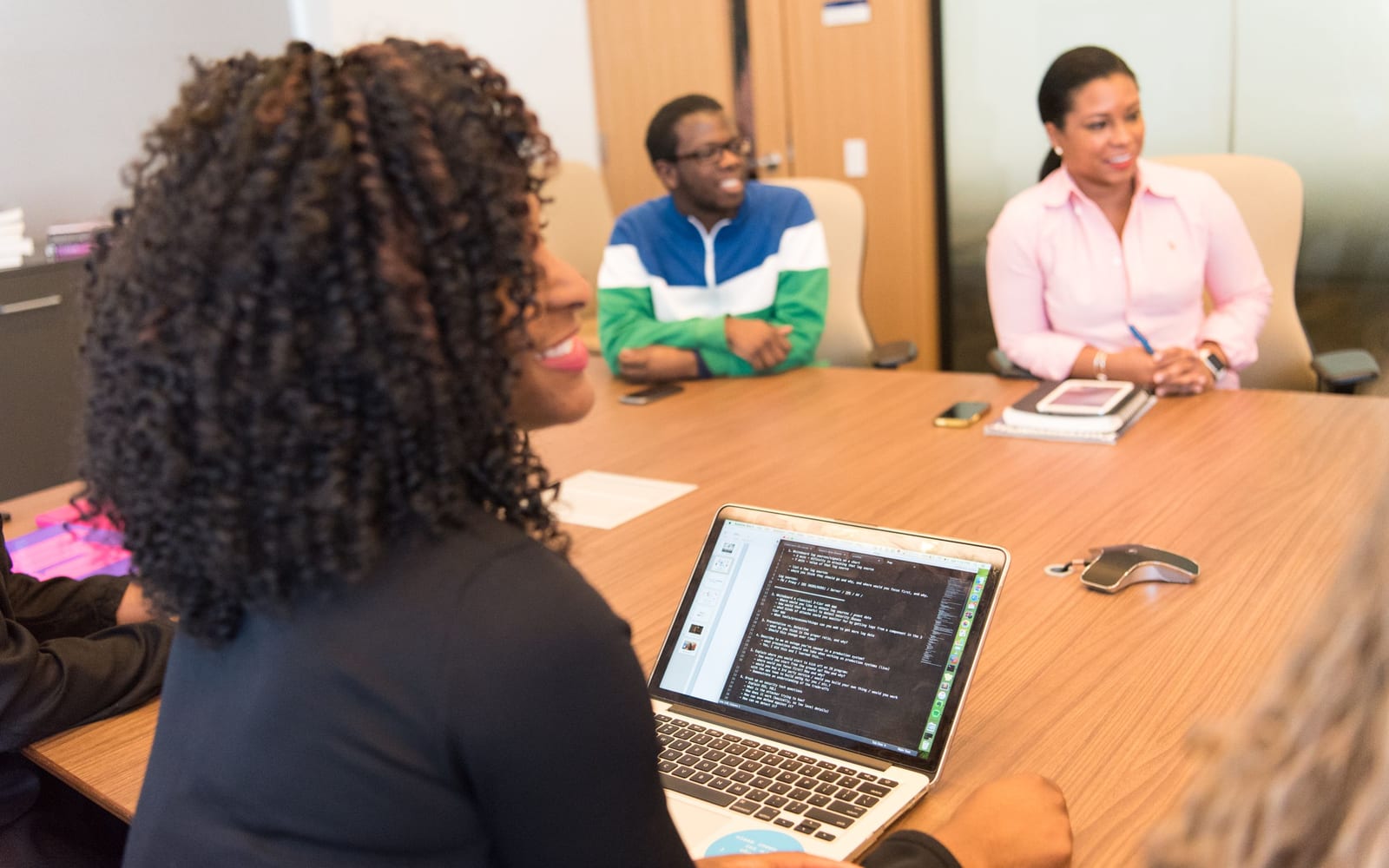 An enterprise meeting in a glass-walled conference room.
