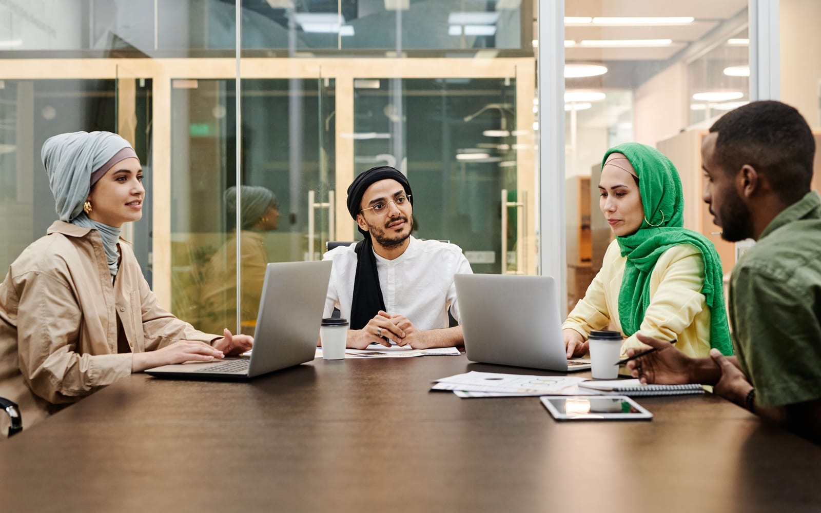 An enterprise meeting in a glass-walled conference room.
