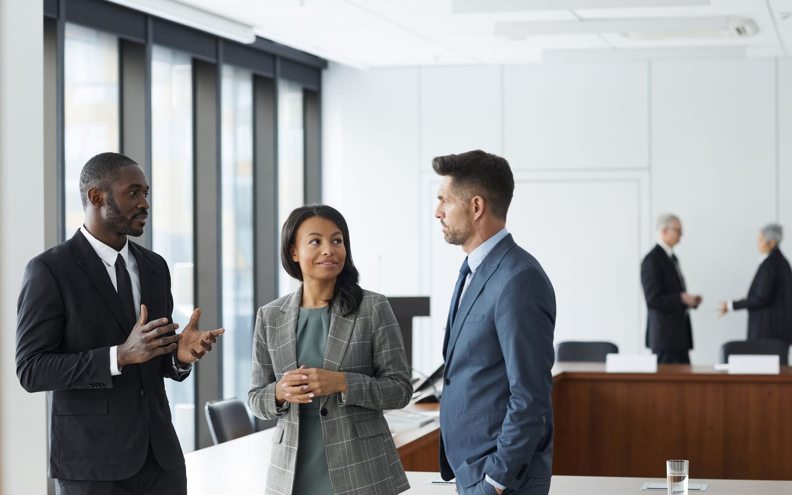An enterprise meeting in a glass-walled conference room.