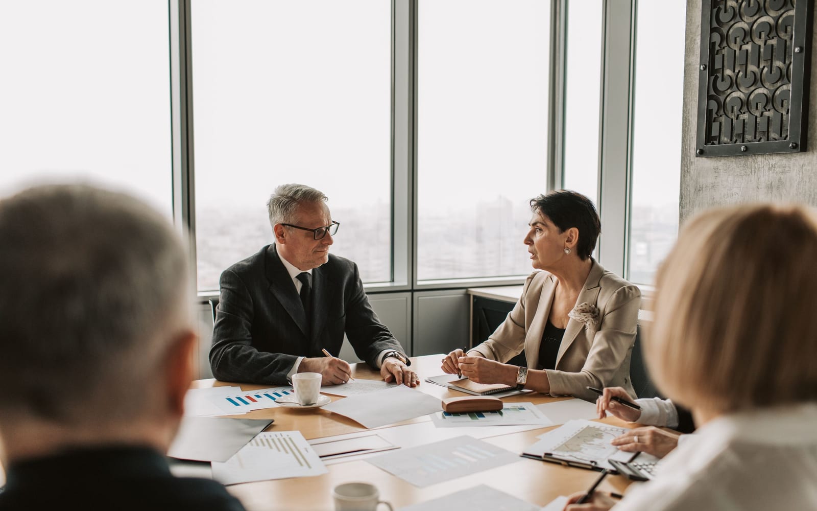 An enterprise meeting in a glass-walled conference room.