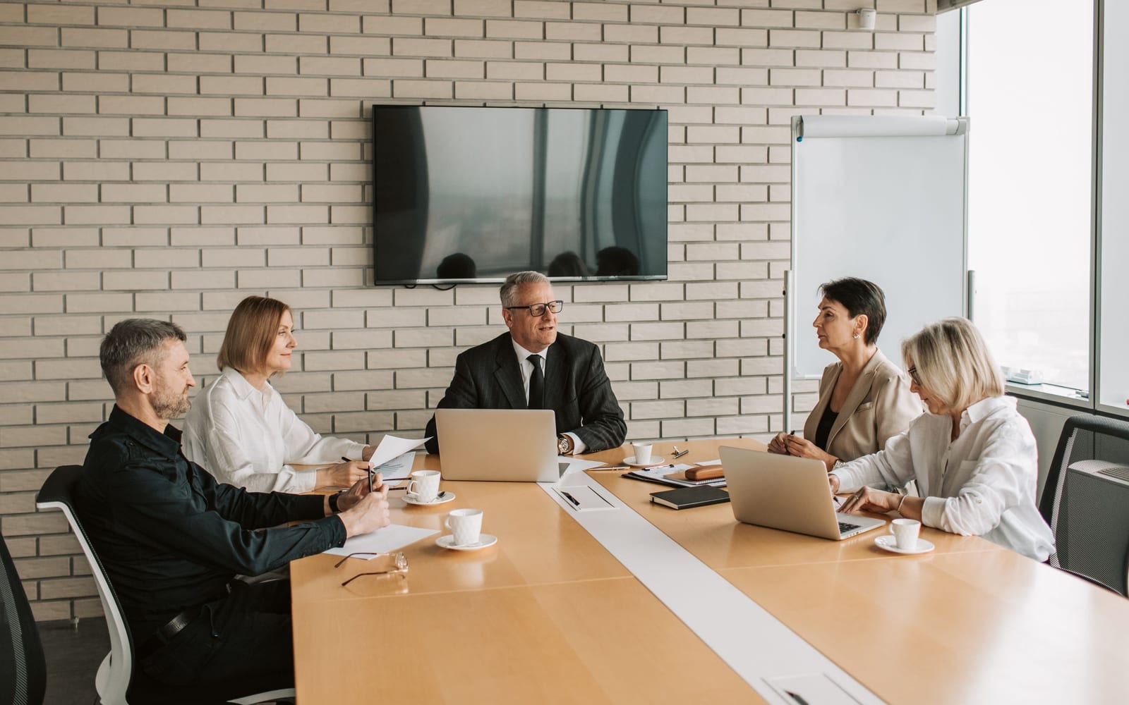 An enterprise meeting in a glass-walled conference room.