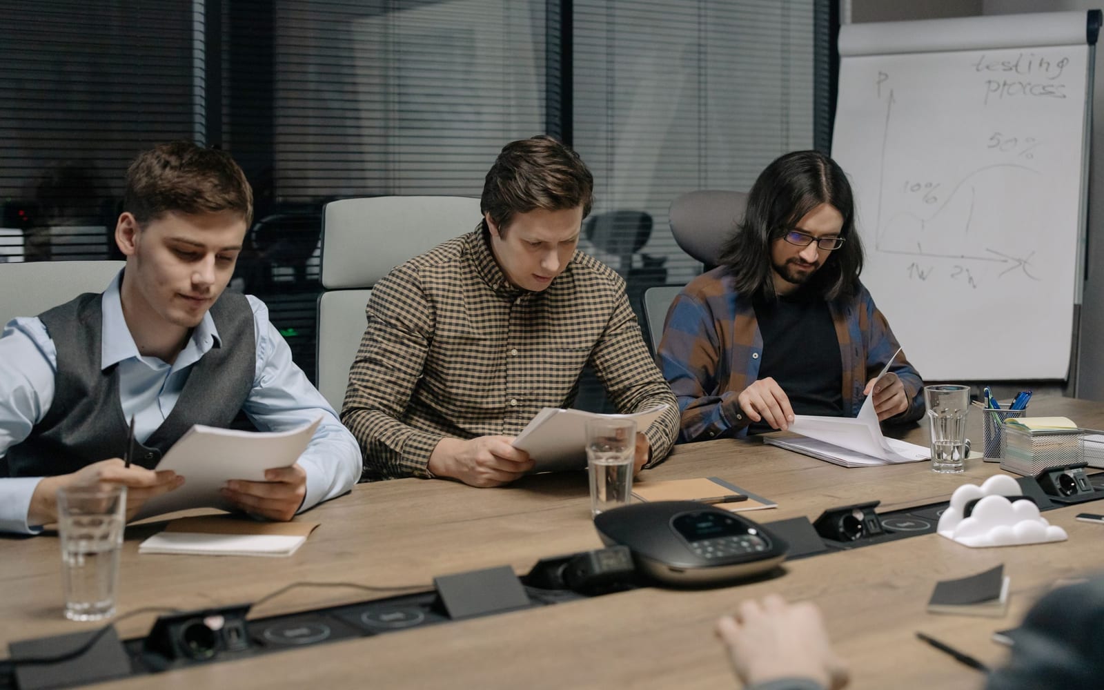 An enterprise meeting in a glass-walled conference room.