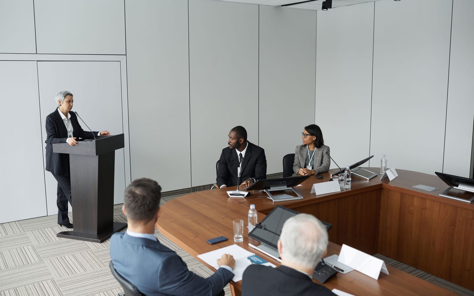 An enterprise meeting in a glass-walled conference room.
