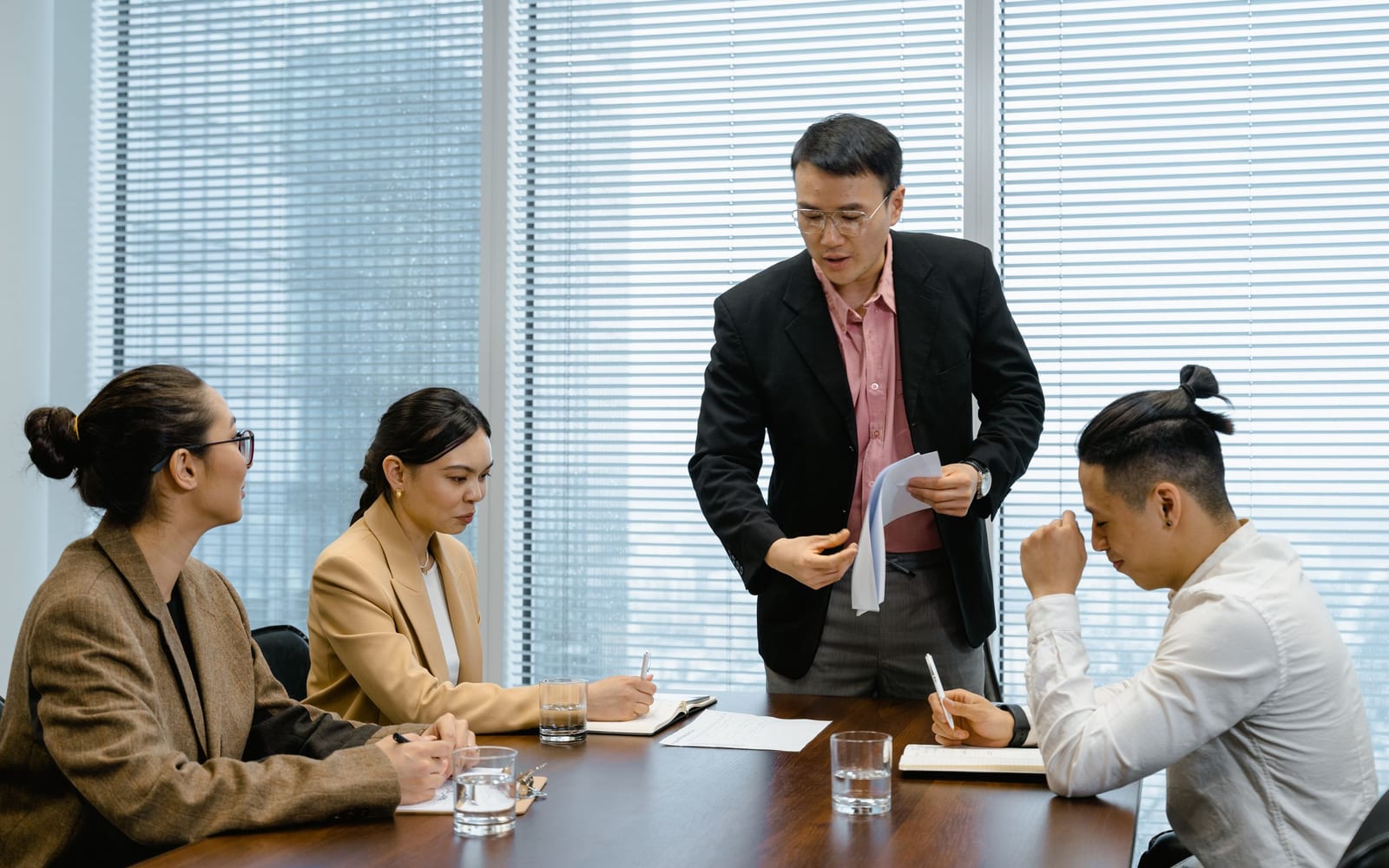 An enterprise meeting in a glass-walled conference room.