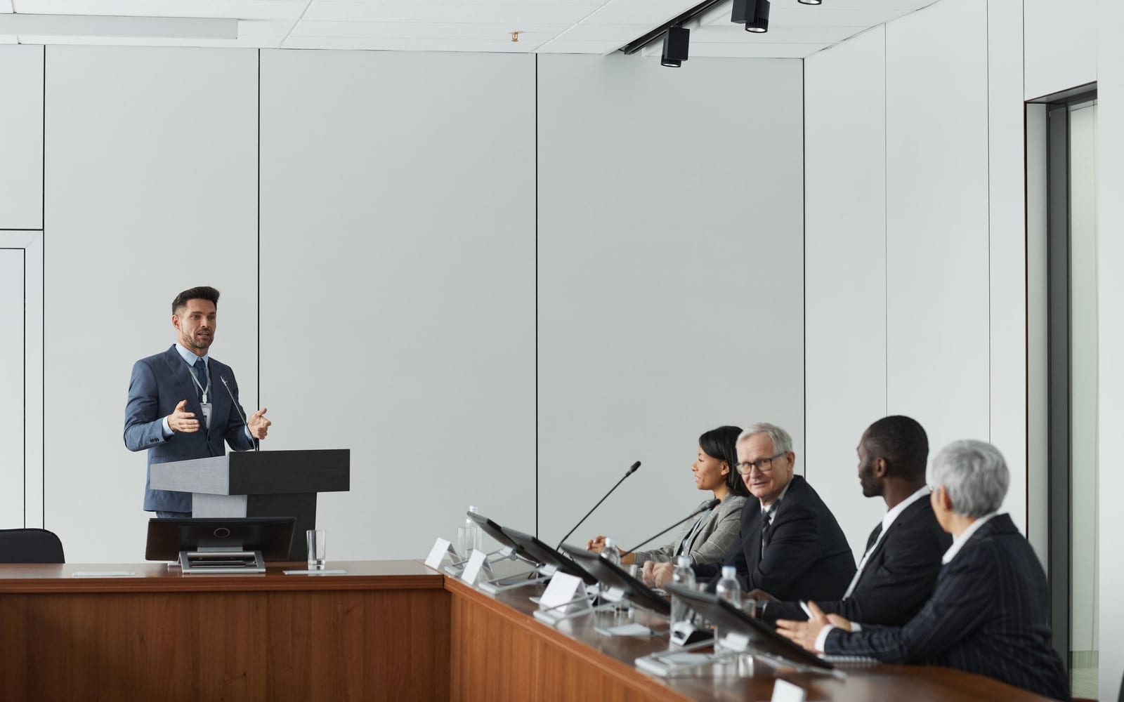 An enterprise meeting in a glass-walled conference room.