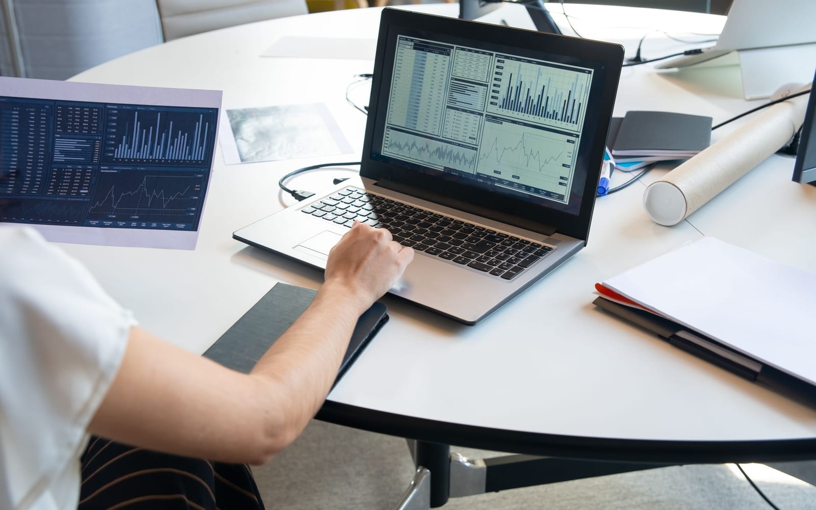 An analyst reviewing figures on a laptop in an office.