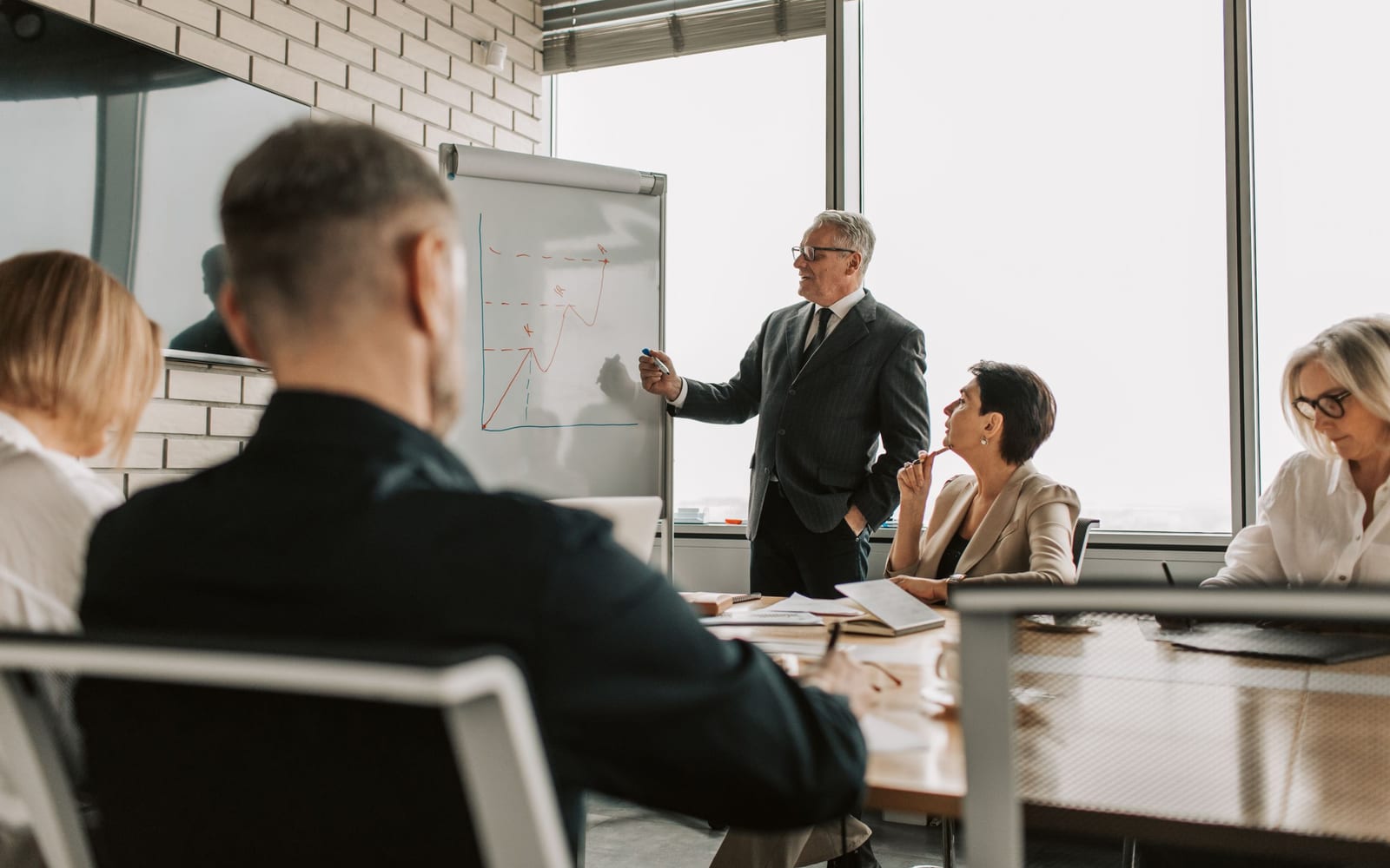 An enterprise meeting in a glass-walled conference room.