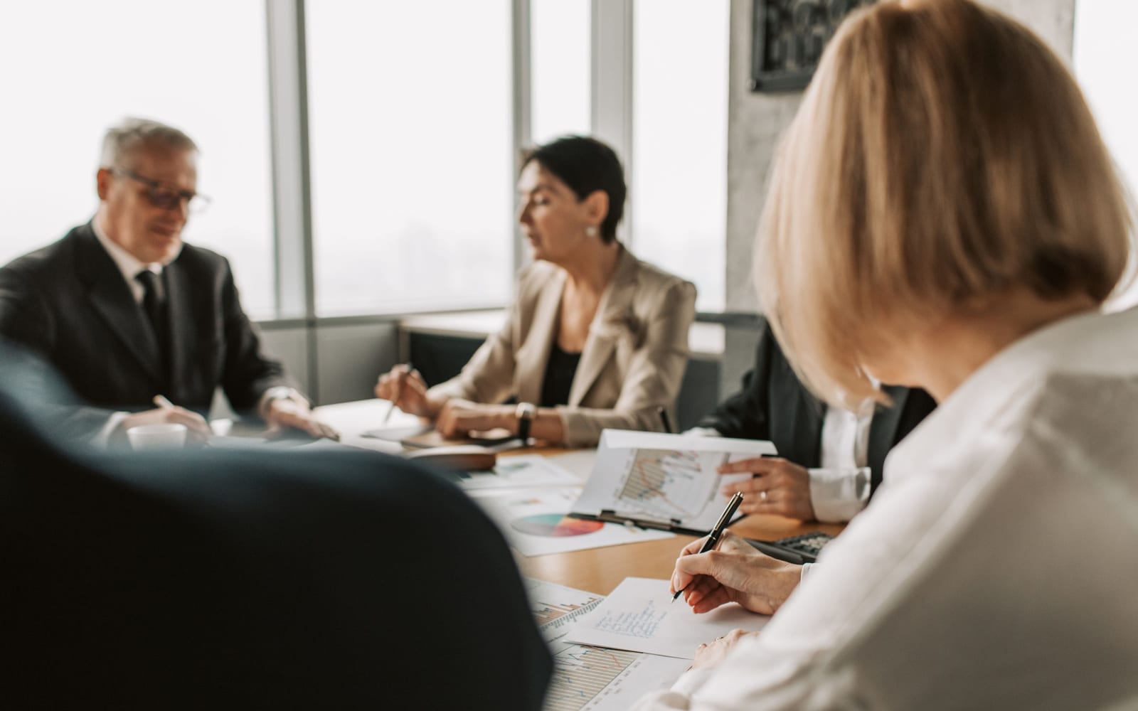 An enterprise meeting in a glass-walled conference room.