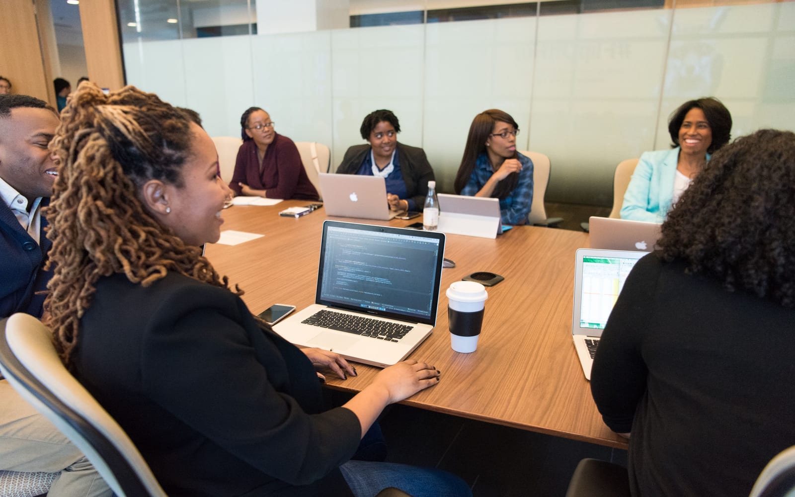An enterprise meeting in a glass-walled conference room.