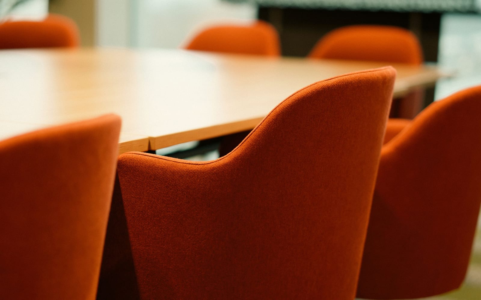 An enterprise meeting in a glass-walled conference room.