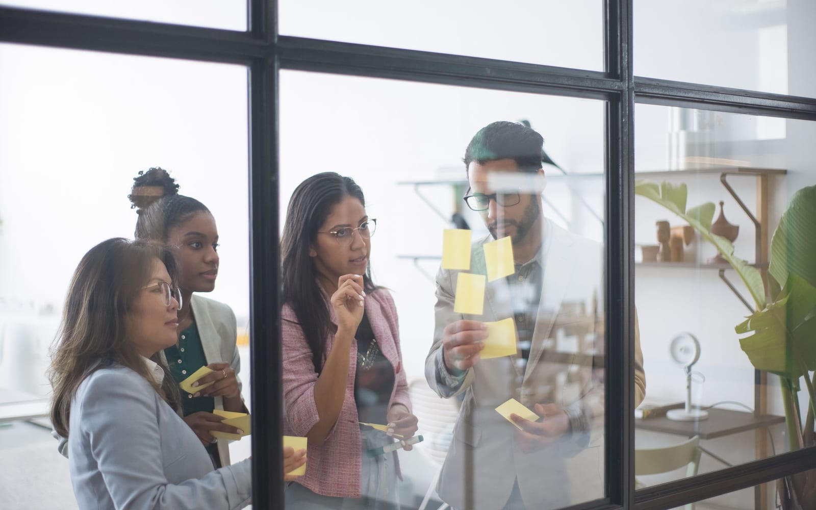 An enterprise meeting in a glass-walled conference room.