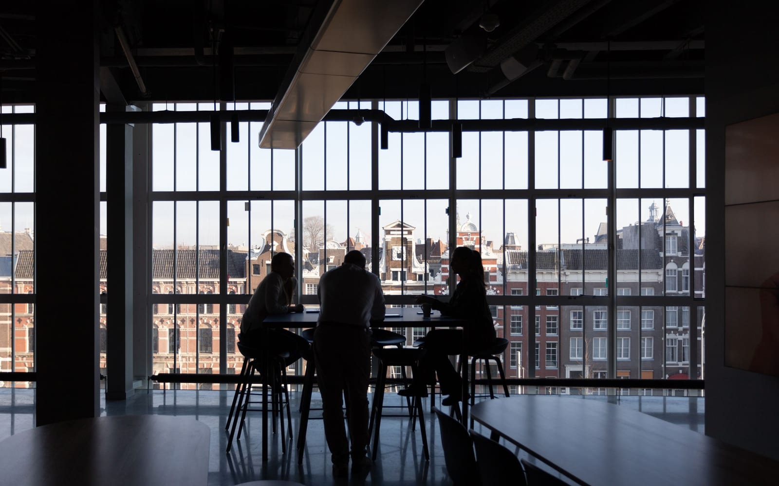 An enterprise meeting in a glass-walled conference room.